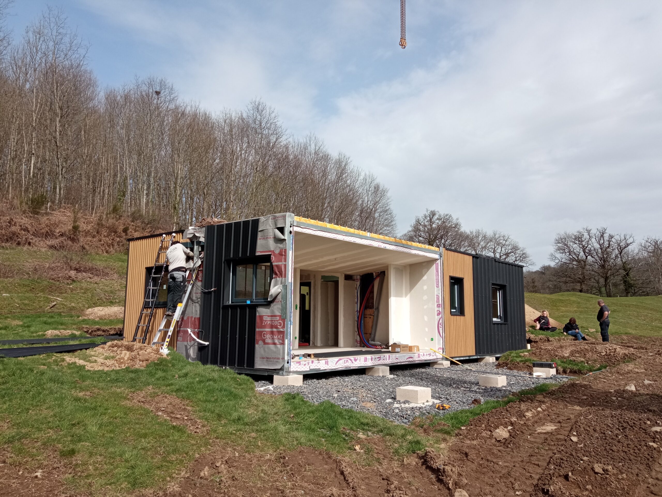 Installation rapide d'une maison modulaire à ossature métallique Modul'Theil avec une grue de levage dans le Cantal.